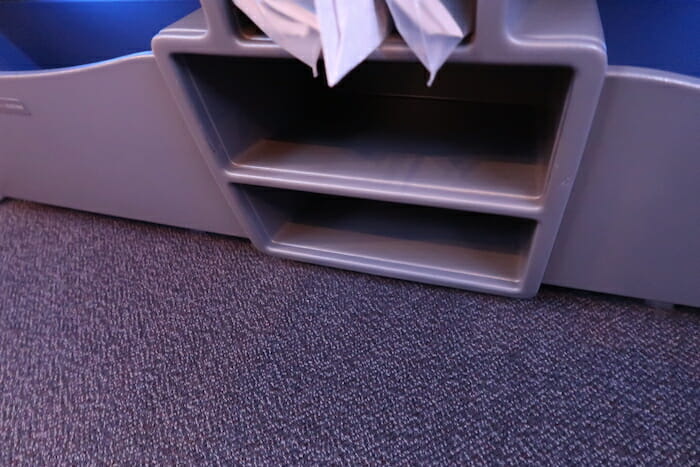 a grey shelf with a bag in it