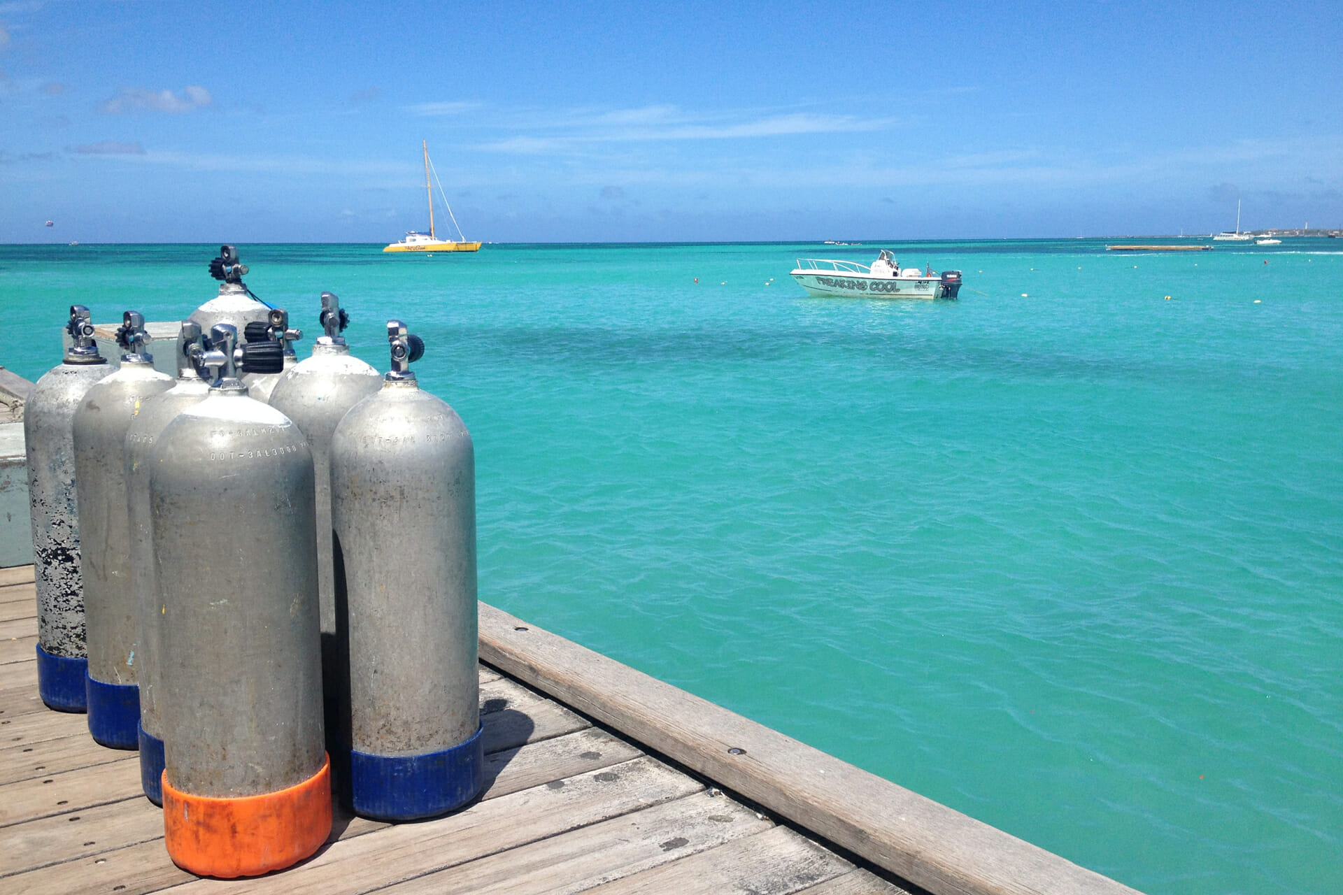 a group of oxygen tanks on a dock next to a boat