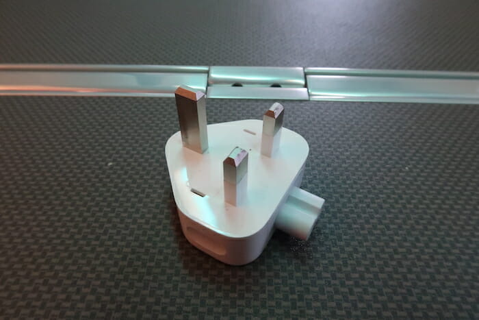 a white electrical plug with metal tips