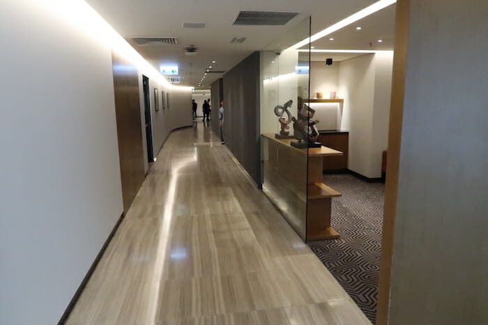 a hallway with a glass wall and a wood floor