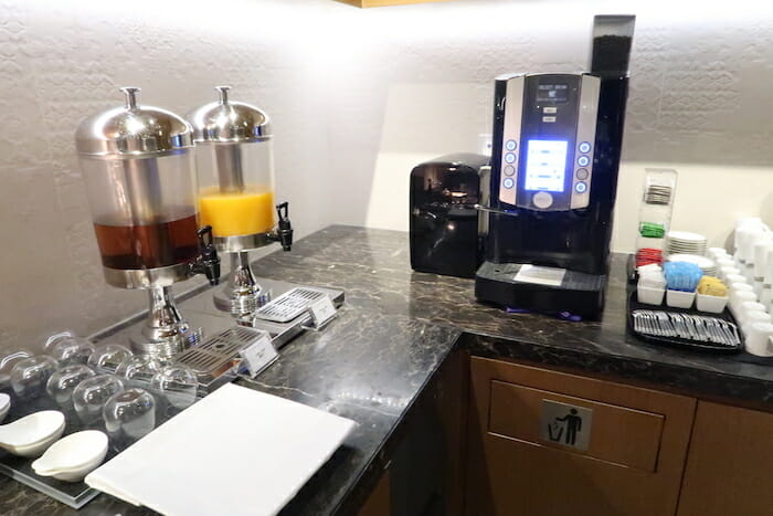 a coffee machine and juice dispenser on a counter