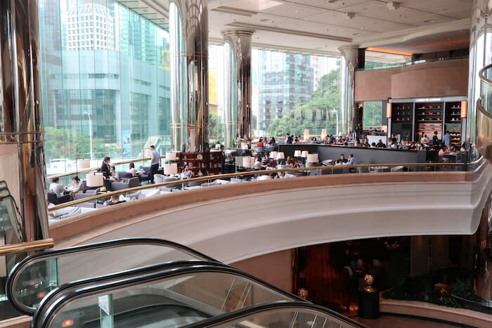 a large building with escalators and people sitting at tables