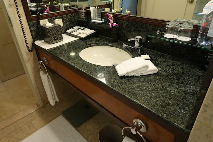 a bathroom sink with a mirror and a towel on the counter