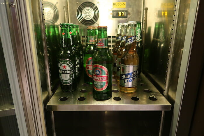 a group of beer bottles on a metal shelf