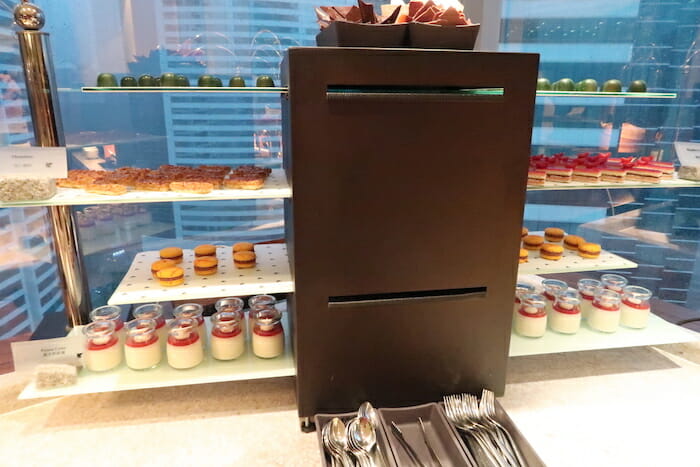 a display case with desserts and spoons