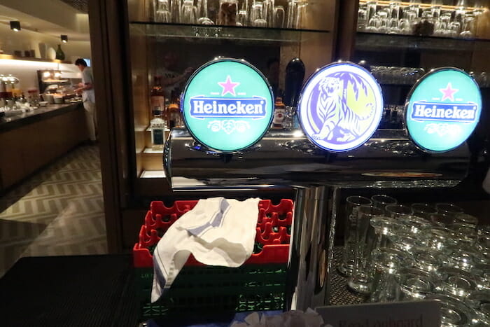 a beer dispenser with glasses and a beer bottle