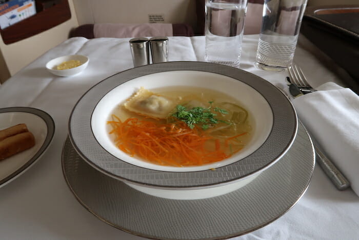 a bowl of soup with carrots and greens