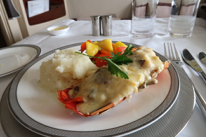 a lobster with cheese and mashed potatoes on a plate