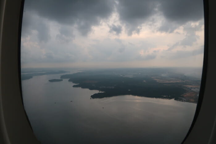 a body of water with land and clouds in the sky