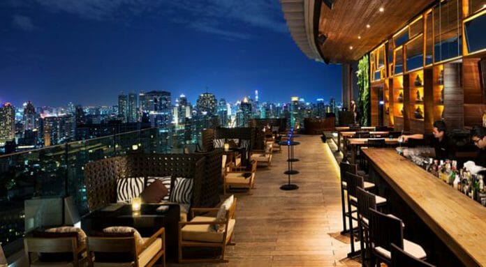 a rooftop bar with a city view