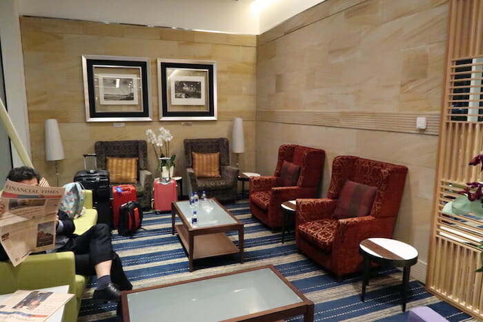 a woman sitting in a chair in a room with chairs and tables