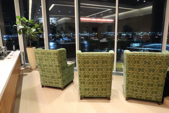 a group of green chairs in a room with large windows