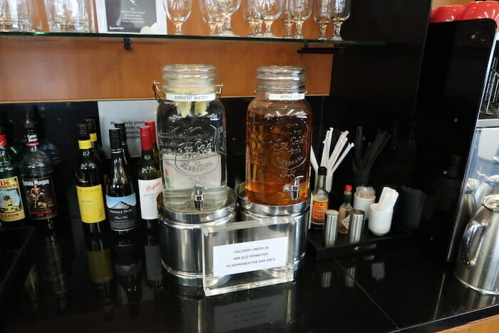 a group of bottles and a drink dispenser on a counter