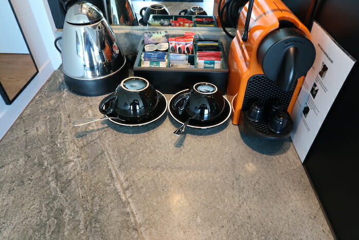 a coffee maker and tea cups on a counter