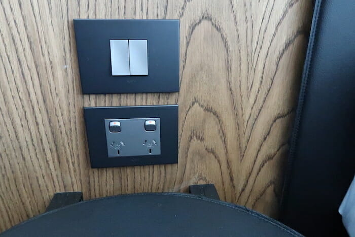 a wall with a light switch and a seat