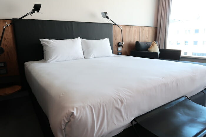 a bed with white sheets and a black table