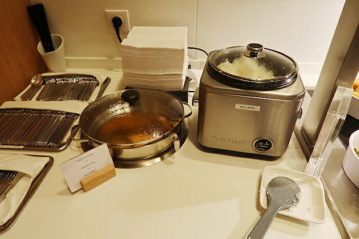 a kitchen counter with utensils and a pot of food