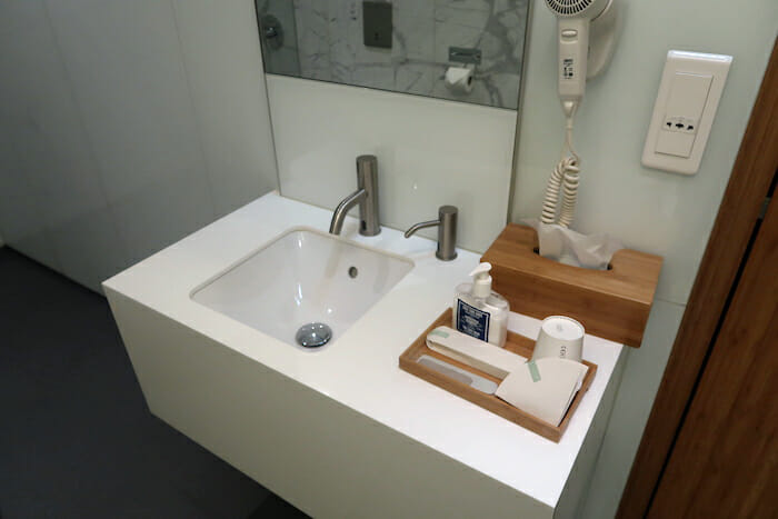 a bathroom sink with a wood tray and a hair dryer