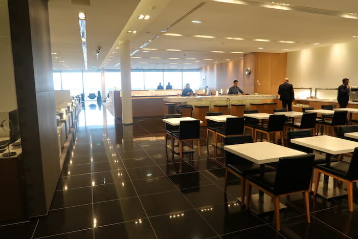 a room with black tile floor and white tables and chairs