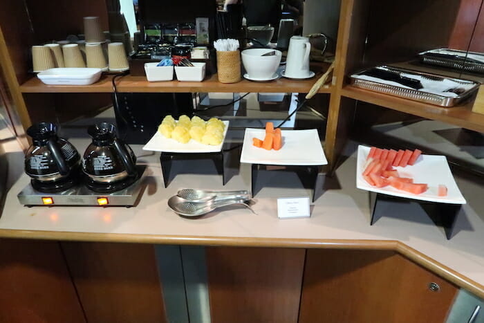 a table with plates of fruit and utensils