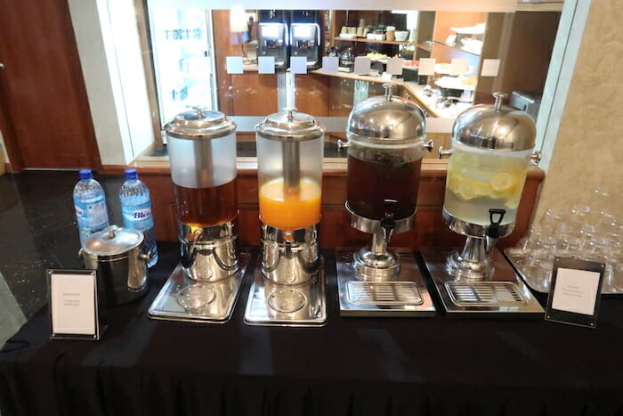 a row of drinks dispensers on a table