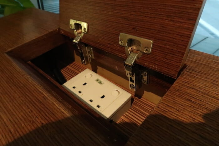 a white outlet in a wood cabinet