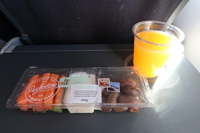 a tray of food and a glass of orange juice