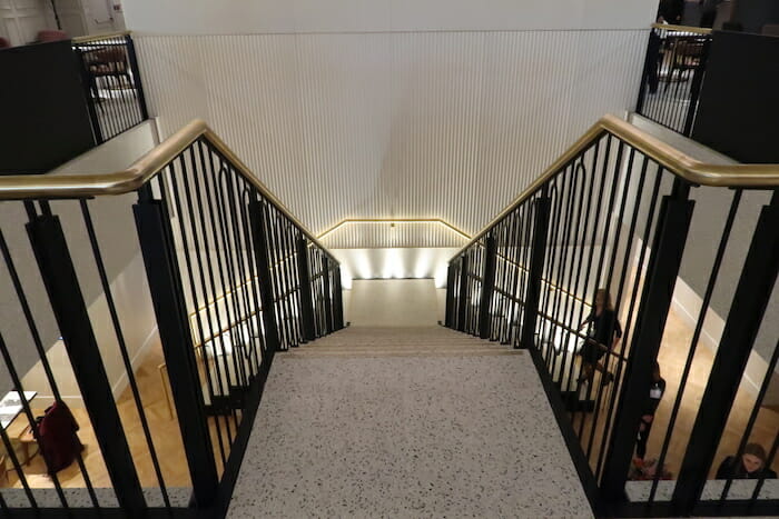 a staircase with black railings and a white wall