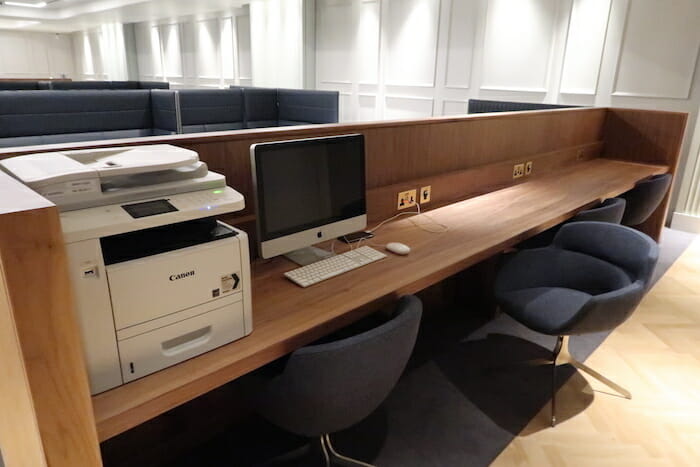 a desk with a computer and a printer