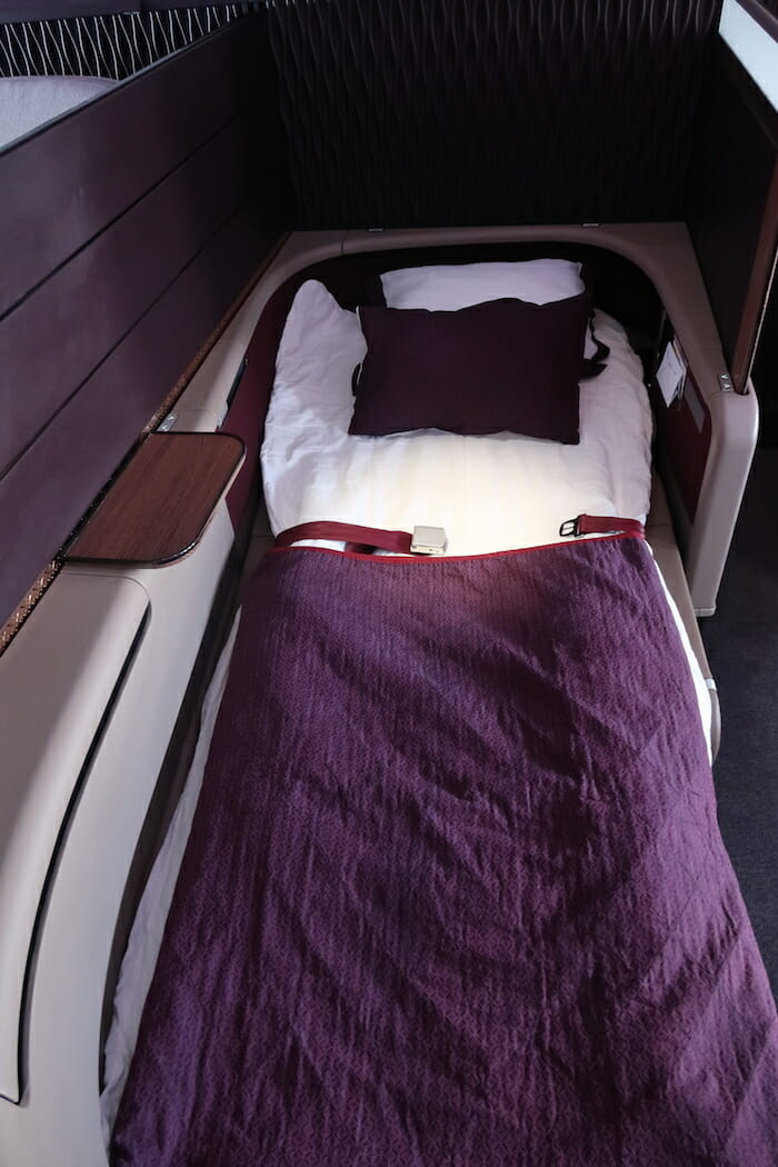 a bed with a seat belt and pillow