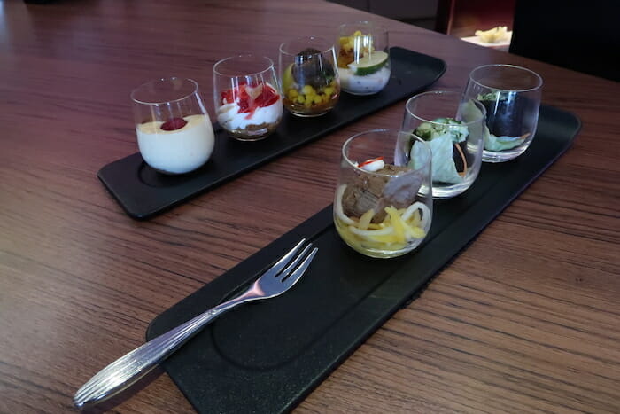 a row of glasses with different food in them