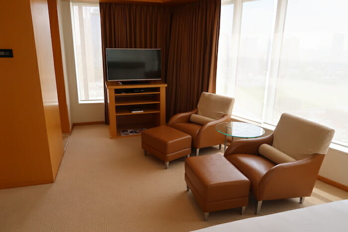 a living room with brown leather chairs and a television