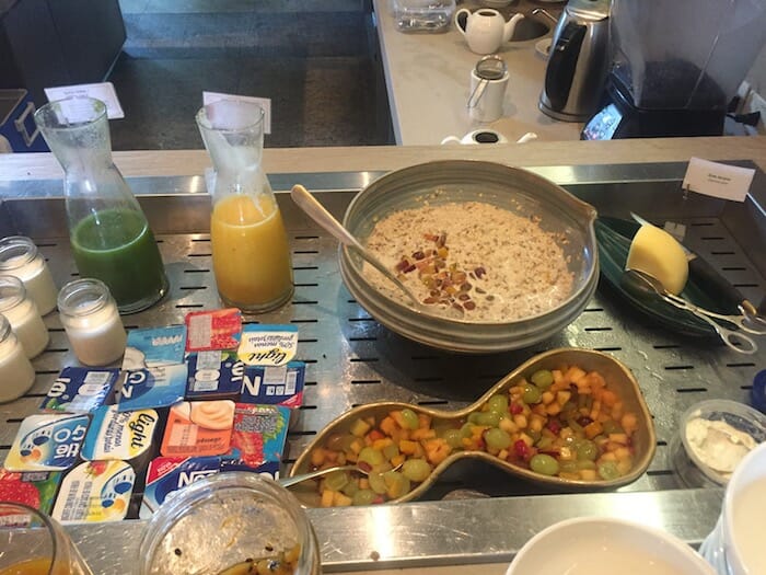 a bowl of oatmeal with fruit and yogurt on a metal tray