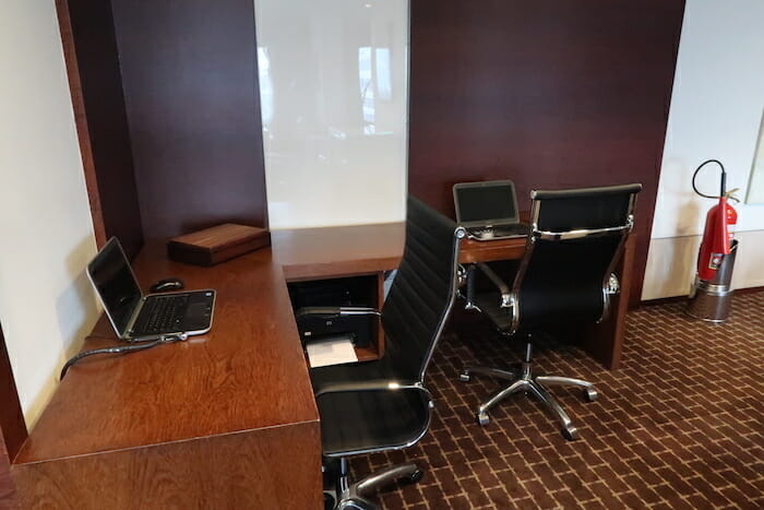 a desk with chairs and laptops