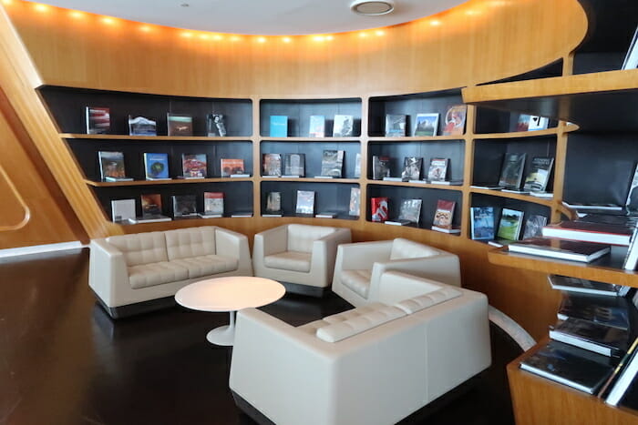 a room with white couches and books on shelves