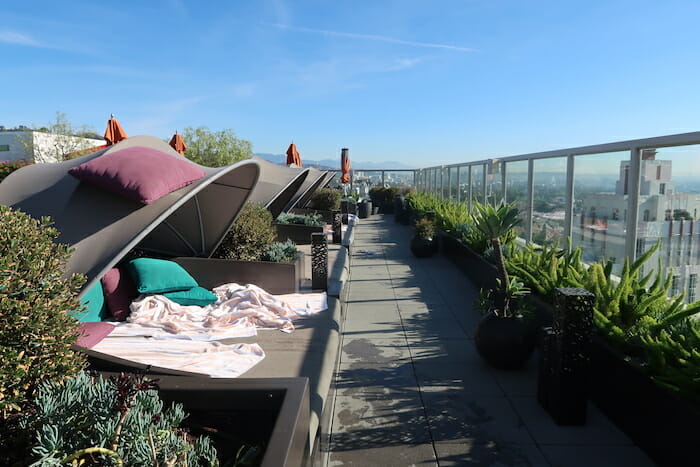 a rooftop patio with a blanket and plants