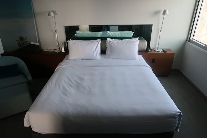 a bed with white sheets and pillows