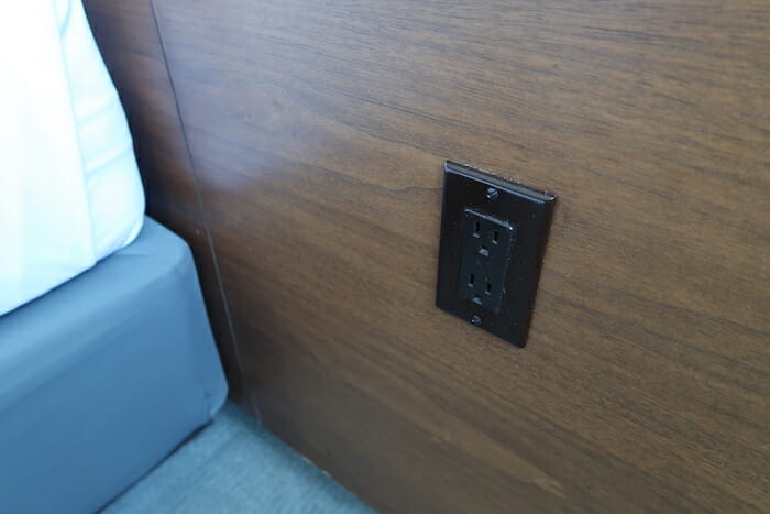 a black electrical outlet on a wood wall