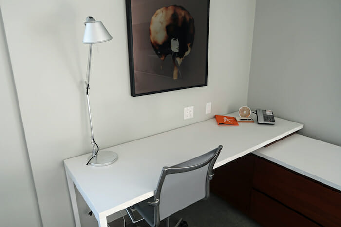 a desk with a picture on the wall