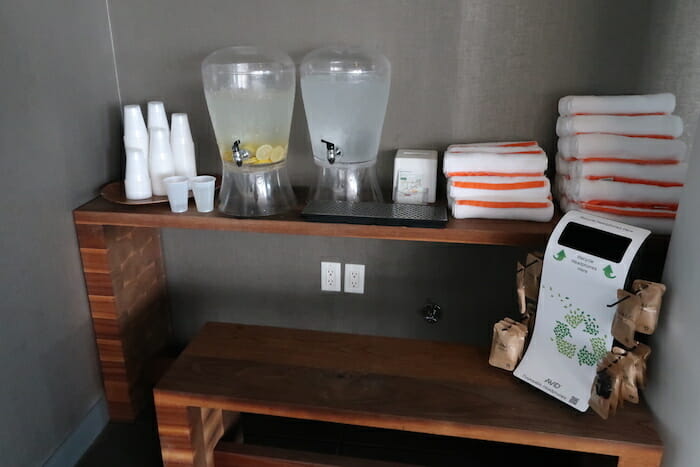 a table with a drink dispenser and towels