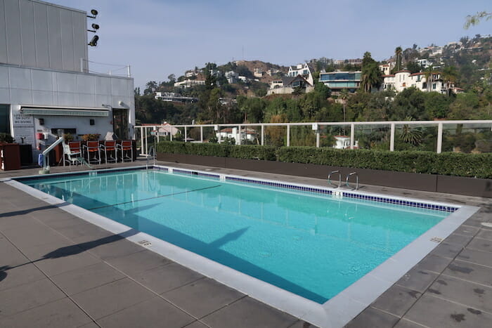 a pool with chairs and a fence