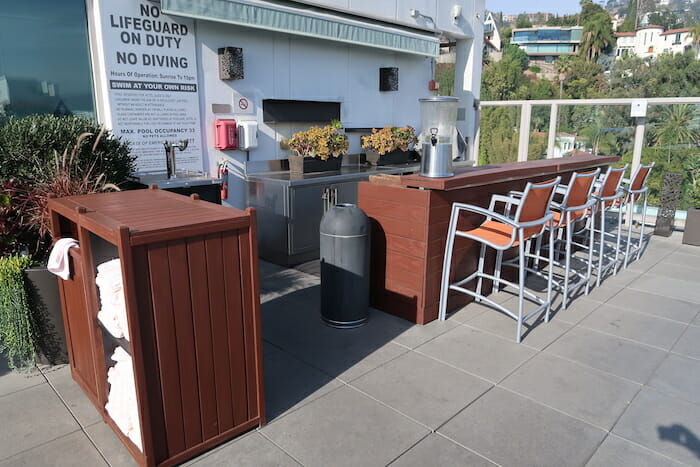 a patio with chairs and a trash can