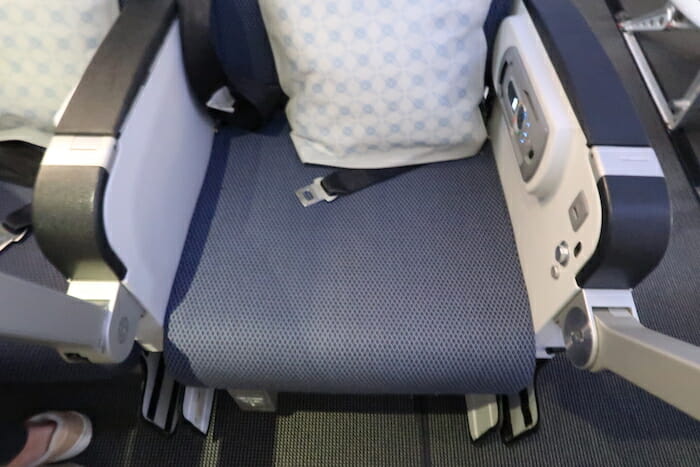 a seat with a pillow and a seat belt