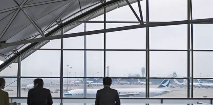 a man looking out a window at an airport