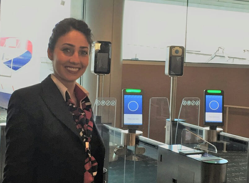 a woman standing in front of a row of electronic screens