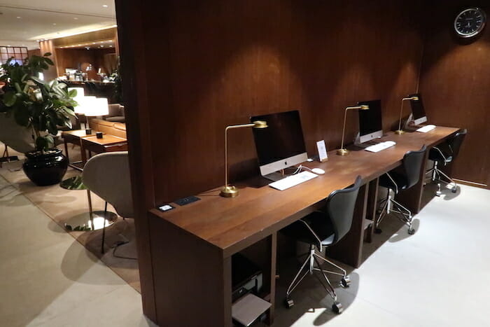 a desk with computers and chairs in a room