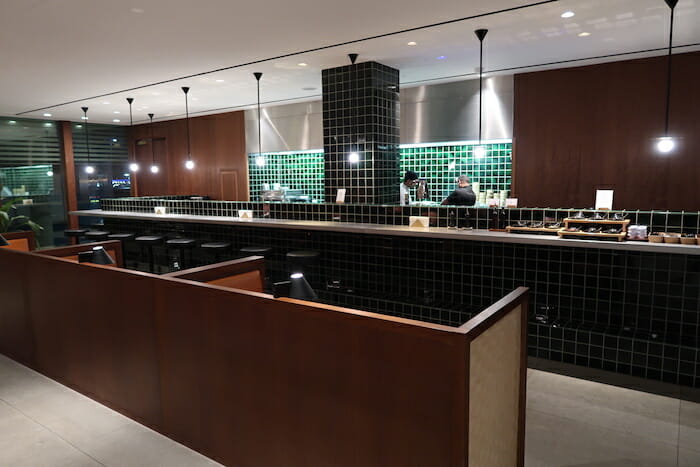 a restaurant with a counter and green tile walls