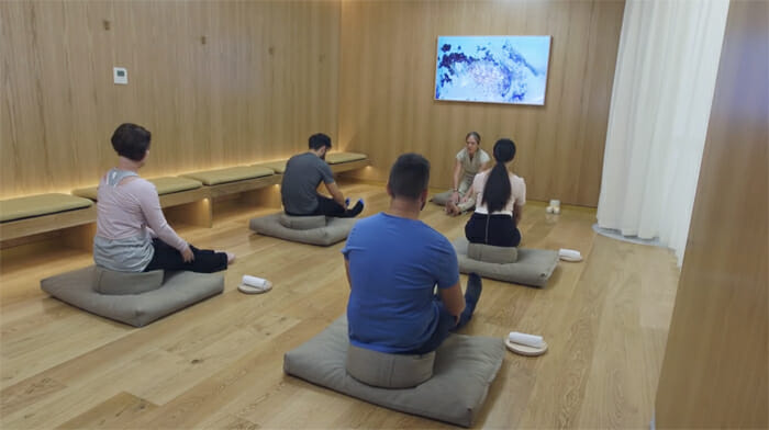 a group of people sitting on pillows in a room