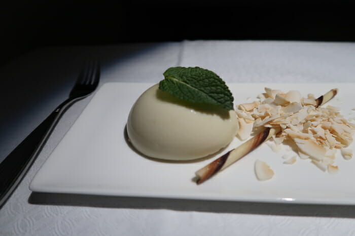 a plate with a white round object with a leaf on it