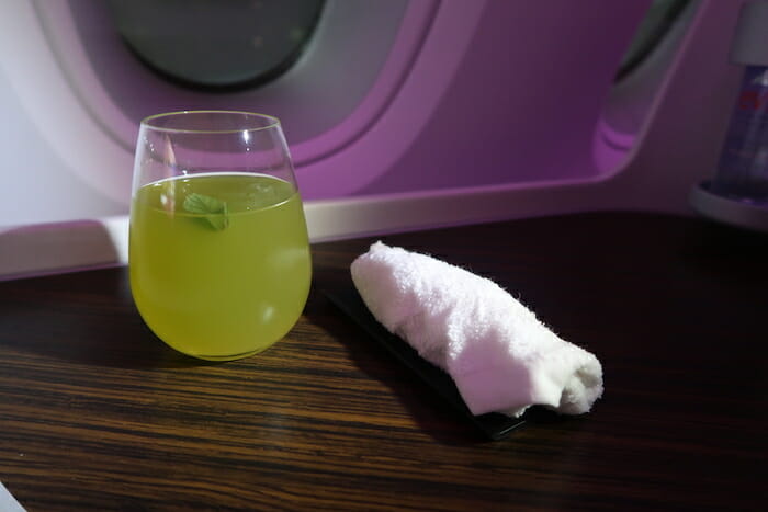 a glass of liquid and a towel on a table